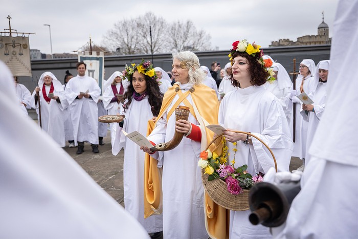 People dressed in white holding flowers