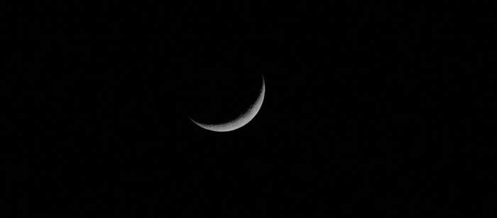 Thin crescent Moon against a black night sky