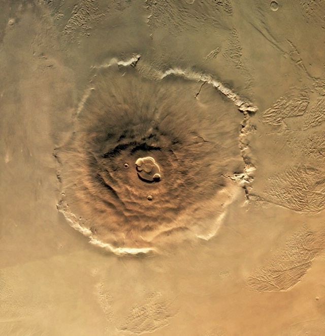 A Viking Orbiter/Lander spacecraft photographed this view of Olympus Mons, the largest volcano in the solar system. It rises 90,000 feet above the surface and is as big as Arizona. | View from: Viking Orbiter/Lander. © Getty Images