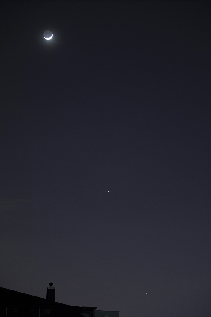 great conjunction of Crescent Moon, Jupiter and Saturn on black sky