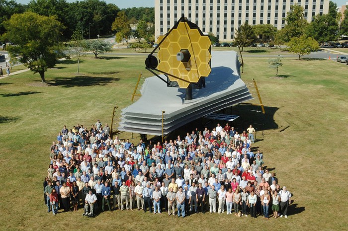 NASA employees stand by a full-scale replica of the James Webb Telescope © NASA