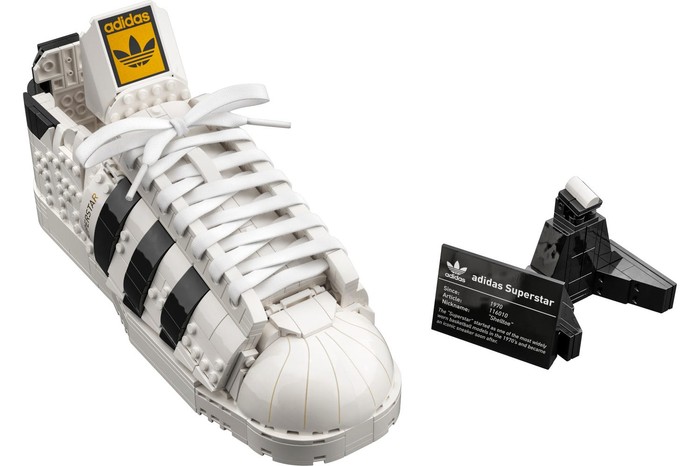 A Lego Adidas shoe and black nameplate on a white background.