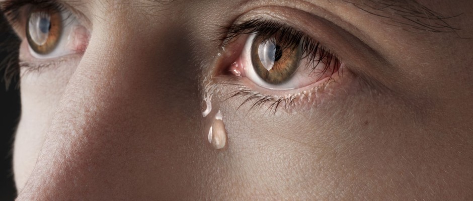 Closeup of young crying man eyes with a tears