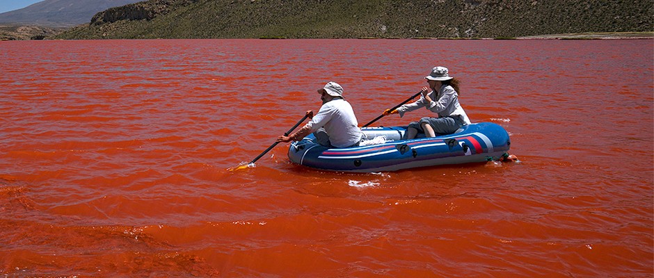 tow people on a boat on a red lake